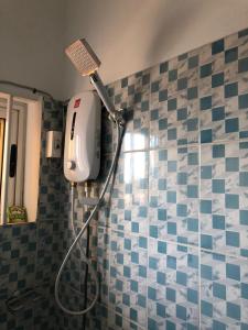 een badkamer met een föhn op een betegelde muur bij Résidence Lotus in Cotonou