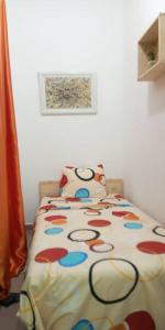 uma cama com um edredão colorido num quarto em Résidence Lotus em Cotonou