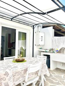 ein Esszimmer mit einem Tisch und Stühlen sowie eine Küche in der Unterkunft Casa Vacanze Longo in Santa Marina Salina