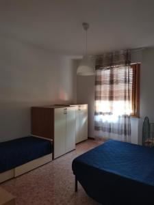 a bedroom with two beds and a dresser and a window at Appartamento Scarperia San Piero a Sieve in San Piero a Sieve