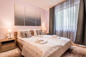 - une chambre avec un grand lit blanc et une fenêtre dans l'établissement Stylish apartment on Bregalnitsa str, à Varna