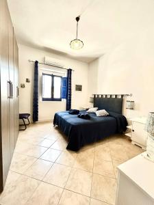 1 dormitorio con 1 cama con edredón azul en Casa Vacanze Longo, en Santa Marina Salina