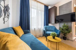 a living room with a blue couch and a tv at Stylish apartment on Bregalnitsa str in Varna City
