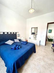 Un dormitorio con una cama azul con almohadas azules. en Casa Vacanze Longo, en Santa Marina Salina