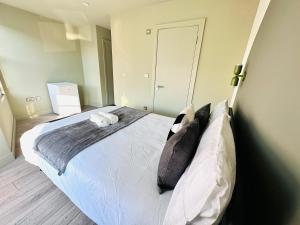 a bedroom with a large bed with white sheets and pillows at Boutique Ensuite Room like hotel in London