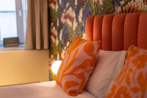 a bed with two orange and white pillows on it at The Melegran in Rovinj
