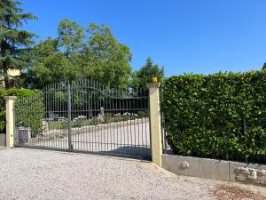 ein schmiedeeisernes Tor mit Blumen im Garten in der Unterkunft Assisi, la Noce in Petrignano