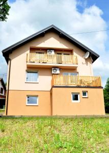 a house with a balcony on the side of it at Apartments Žugec in Seliste Dreznicko