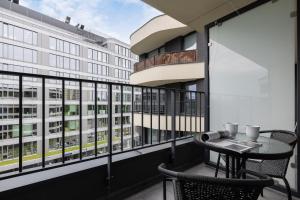 - Balcón con mesa y sillas en un edificio en Modern Apartment suitable for Remote Work with Balcony & Parking by Renters, en Cracovia
