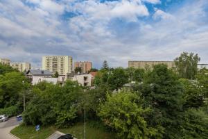 vistas a una ciudad con edificios y árboles en Modern Apartment suitable for Remote Work with Balcony & Parking by Renters, en Cracovia