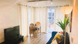 a living room with a couch and a table and a television at Bridgefield Apartment in Ashford