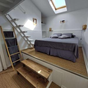 a bedroom with a bed and a staircase in a room at La Cas'Aline in La Saline les Bains