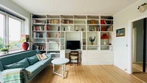 a living room with a blue couch and a tv at ApartmentInCopenhagen Apartment 700 in Copenhagen