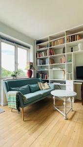 un soggiorno con divano verde e librerie di ApartmentInCopenhagen Apartment 700 a Copenaghen