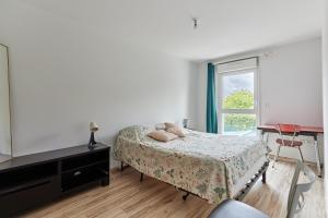 a bedroom with a bed and a tv and a window at Les Rochambelles - Maison avec terrasse in Ifs