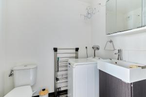 a white bathroom with a toilet and a sink at Les Rochambelles - Maison avec terrasse in Ifs +6 photos