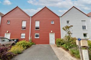 a row of red buildings with a car parked in front at Les Rochambelles - Maison avec terrasse in Ifs
