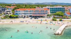 a group of people in the water at a beach at Hotel Duje in Vodice