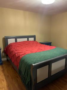 a bedroom with a bed with a red comforter at Lemon Tree Inn in Fort McMurray