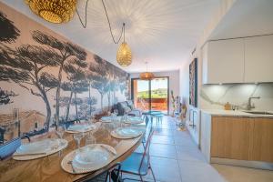 uma sala de jantar com uma mesa longa e cadeiras em L'Escale de Collioure - Climatisé, parking privé sécurisé, vue mer em Collioure