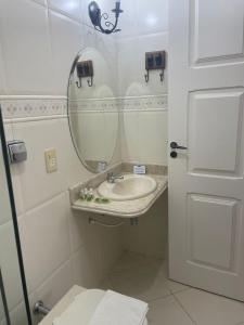 uma casa de banho com um lavatório, um espelho e um WC. em Pousada Pedra Pimenta em Tiradentes