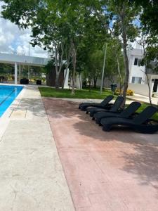 a row of lounge chairs next to a swimming pool at Cancun 16, South 6 Person 3 Rooms 15 min Airport 20 to Beach in Cancún