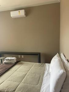 1 dormitorio con 1 cama grande y aire acondicionado en Pousada Pedra Pimenta, en Tiradentes