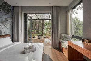a bedroom with a bed and a large window at Les Rêveurs Dalat in Xuan An