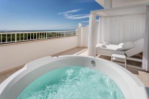 a hot tub on a balcony with a view of the ocean at Garden Playanatural - Adults Only in El Rompido