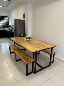 een houten tafel en bank in een keuken bij Murni Guesthouzz 2 in Kampong Alor Gajah