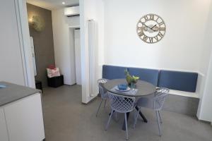 a dining room with a table and chairs and a clock at Casetta al mare in Barletta