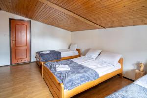 a bedroom with two beds and a wooden ceiling at Ski Lodge - pokoje 200 m od Gondoli w Szczyrku (Biuro Apartament Na Urlop) in Szczyrk