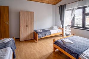 a bedroom with two beds and a window at Ski Lodge - pokoje 200 m od Gondoli w Szczyrku (Biuro Apartament Na Urlop) in Szczyrk
