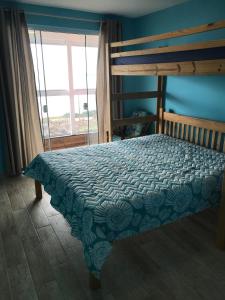 1 dormitorio con 1 cama con pared azul en Melhor vista para o mar, en Penha