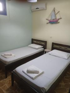 two beds in a room with a boat on the wall at Efi in Káto Alepokhórion