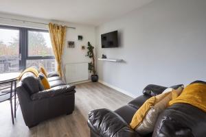 a living room with two leather couches and a table at Host & Stay - London Avenue in Glasgow