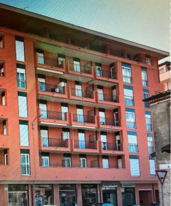 un gran edificio de ladrillo rojo con muchas ventanas en APPARTAMENTO MAZZINI, en Angera