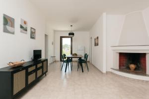 sala de estar con chimenea, mesa y sillas en Villetta L'Ajara, en Ortelle