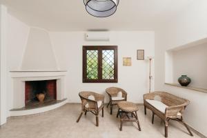 sala de estar con sillas, mesa y chimenea en Villetta L'Ajara, en Ortelle