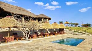 un complejo con piscina y cabañas con techo de paja en Africa Safari Karatu, en Karatu