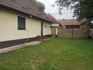 a backyard of a house with a fence at Eva's Little House - Acasă la Tăticul Albinelor in Şinca Veche