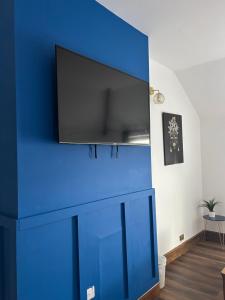 Una pared azul con una TV encima. en City Escape , 10 mins walk to the City Centre and Principality Stadium Sleeps 5, en Cardiff