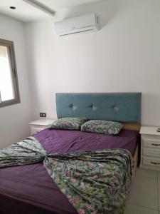 a bedroom with a purple bed with a blue headboard at المغرب القنيطره in Kenitra