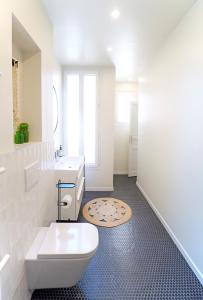 a white bathroom with a toilet and a sink at Villa Adèle, Sauna et Balcon vue Mer - Appt 03 in Mers-les-Bains