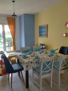 a dining room with a table with blue bowls on it at Amor de Skioni in Nea Skioni