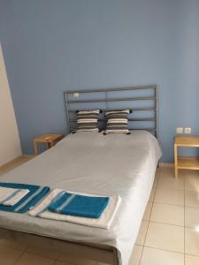 a bed in a bedroom with a blue wall at Amor de Skioni in Nea Skioni