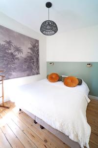 1 dormitorio con 1 cama con almohadas de color naranja en Villa Adèle, Sauna et Balcon vue Mer - Appt 03 en Mers-les-Bains