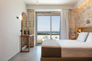 a bedroom with a bed and a view of the ocean at Petras Luxury Villas in Falasarna