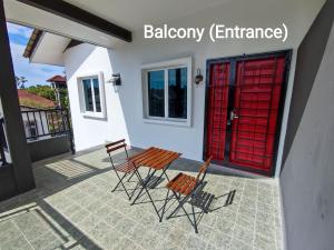 two chairs and a red door on a patio at 4A Home2Stay in Kota Bharu