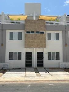a white building with black doors on a street at Cancun 16, South 6 Person 3 Rooms 15 min Airport 20 to Beach in Cancún